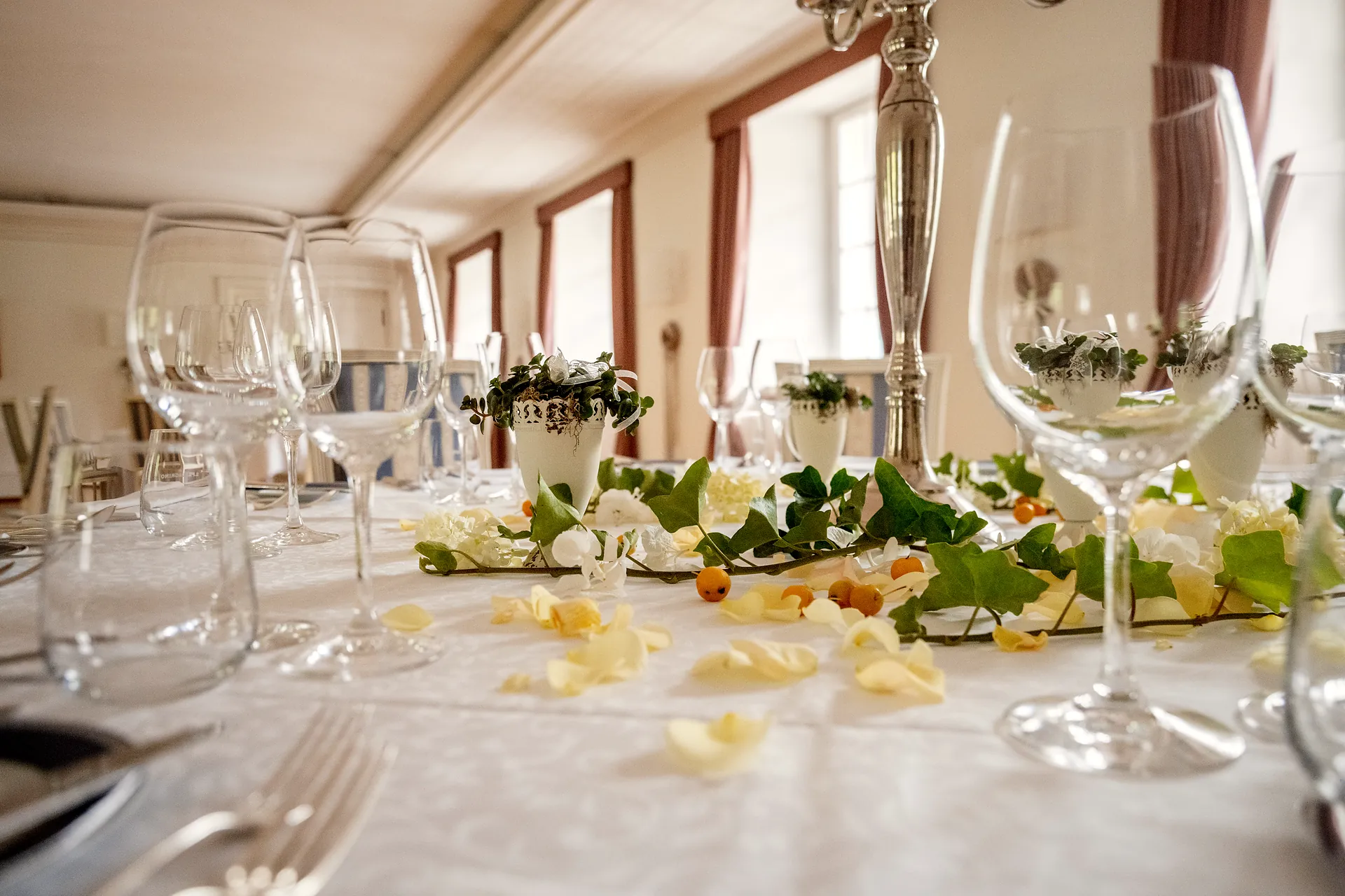 Gedeckter Tisch mit Gläsern und Blumen vor dem Abend