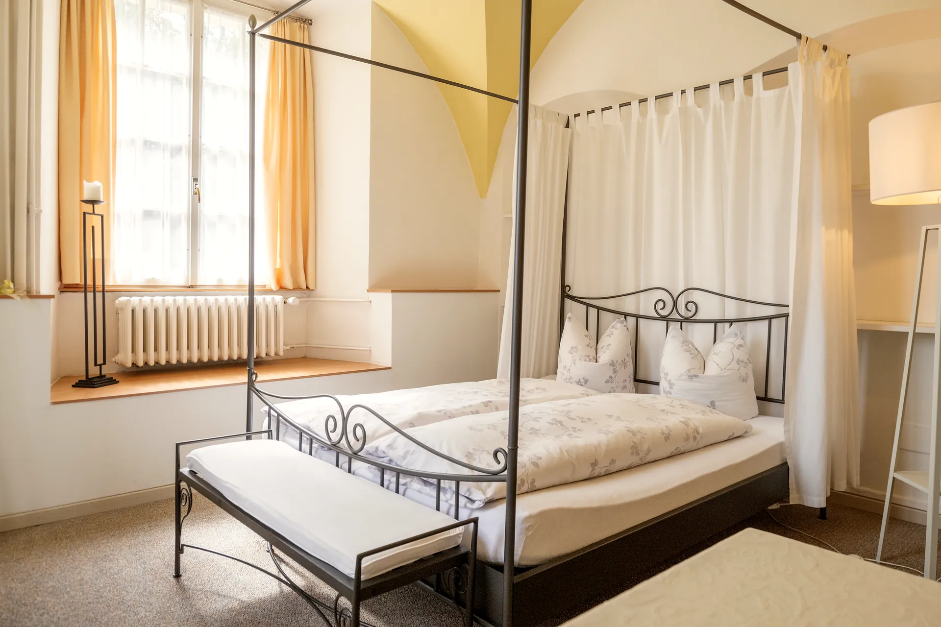 Hotelzimmer im Château Attisholz mit Metallbett und Tageslicht